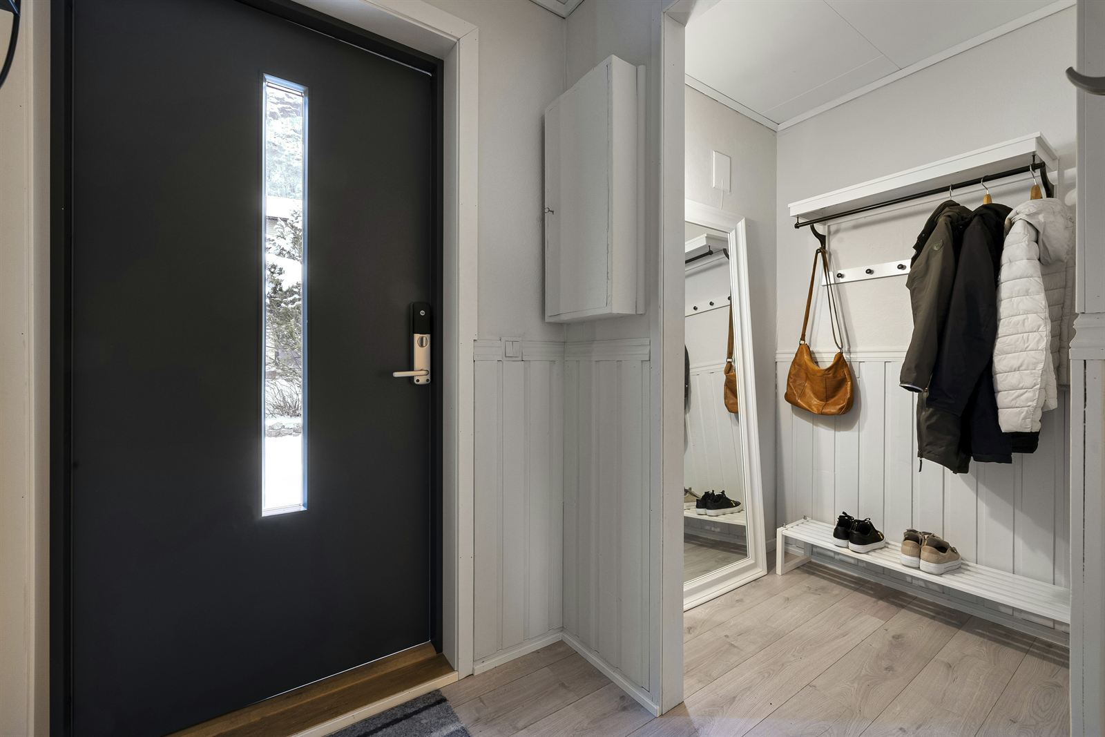 Small entryway with white wall hooks and shelves organizing bags, coats, and shoes with affordable space-saving storage. Small entryway with white wall hooks and shelves organizing bags, coats, and shoes with affordable space-saving storage.