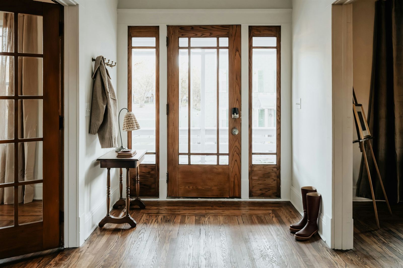 Small entryway with a wood front door, narrow table, and wall hooks creating practical organization in a limited space. Small entryway with a wood front door, narrow table, and wall hooks creating practical organization in a limited space.