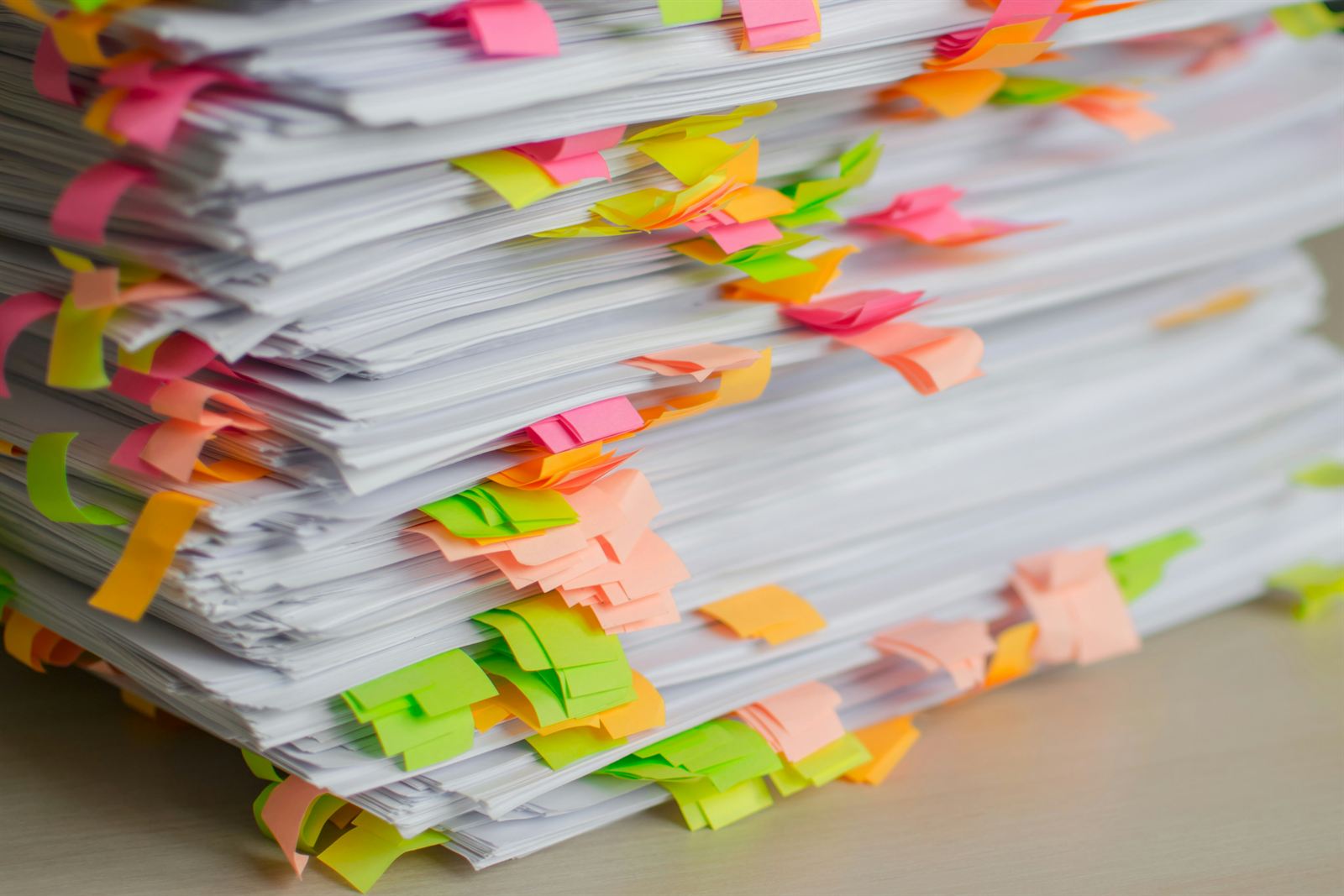 Stacks of paper documents marked with colorful sticky tabs for sorting paperwork and organizing home office files. Stacks of paper documents marked with colorful sticky tabs for sorting paperwork and organizing home office files.