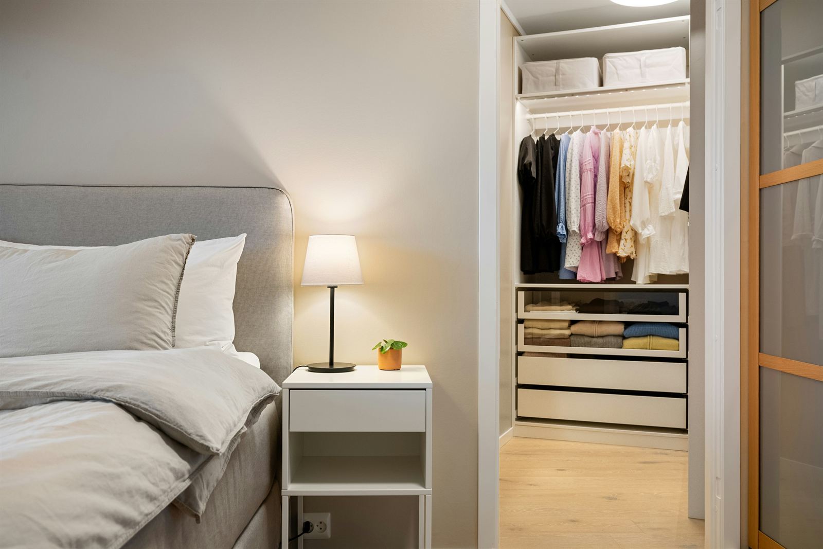 Small organized closet with hanging clothes, storage bins, shelves, and drawers that maximize closet storage space. Small organized closet with hanging clothes, storage bins, shelves, and drawers that maximize closet storage space.